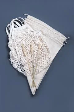 The reusable string bags on the grey background with three wheat spikelets. Stock Photos