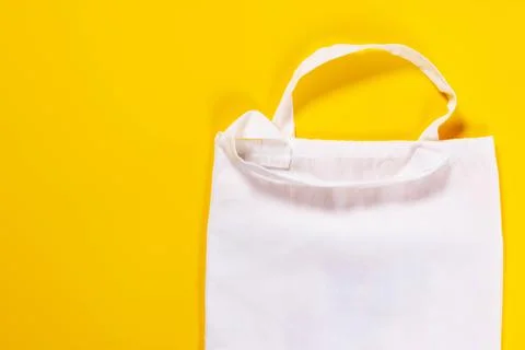 Reusable textile bag with drawstring on a yellow background. Reusable eco bag Stock Photos