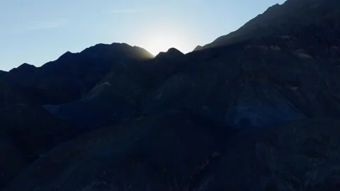 Reveal dron shot of sun rays during sunrise over big rocky mountain in argentina Vídeos de archivo 343408322