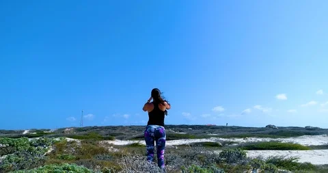 Reveal fly out of model standing on top of white dunes looking at lighthouse Stock-Footage 104577273