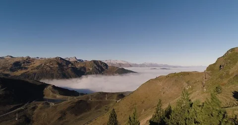 Reveal over trees to see clouds filling valley in mountain range drone aerial 4k Stock Footage 125758320