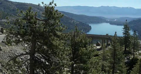 Reveal from pine tree to Donner Summit bridge and lake view aerial in summer Vidéo 203926058