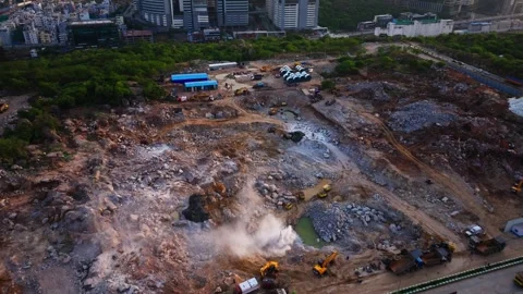 Reveal shot of rock blasting in massive construction site with parked heavy Stock Footage 342279979