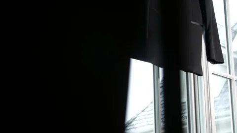 Reveal of suit jacket hanging in window Stock Footage 107991209