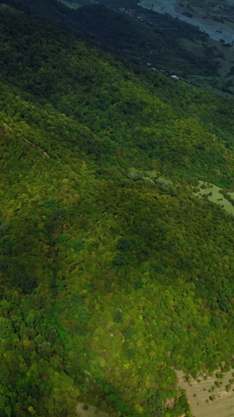 Revealing river and mountains with clouds in Georgia. camera tilts up on a drone Stock Footage 255634209