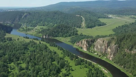 Revealing shot of a river flowing among green forest and mountains Vídeos de archivo 263063053