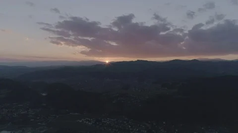 Revealing the small orange sun before it fully disappears into the horizon, 4K Stock Footage 73851595
