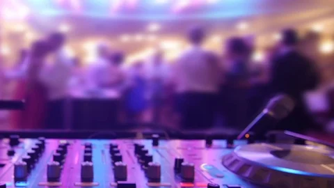Revelers dancing in front mixing console beyond the scaffolding with l Stock Footage 71048733