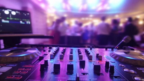 Revelers dancing in front mixing console beyond the scaffolding with l Stock Footage 71452944