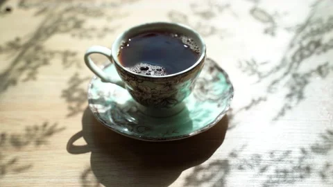The revers effect. Black tea pours out from the beatiful cup. Steam comes from Stock Footage 134011607