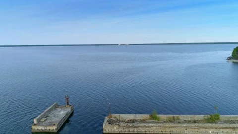 Reverse aerial of abandone submarine base and dock in Estonia Stock Footage 92352247