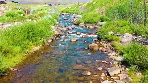 Reverse aerial along a Yosemite style mountain stream in California with Stock Footage 333403360