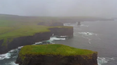 Reverse aerial dolly of Kilkee cliffs on a misty day revealing Bishop Stock Footage 282158114