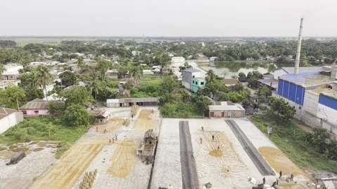 Reverse Aerial Flight Above Rice Processing Facilities in Bangladesh Stock Footage 337978929