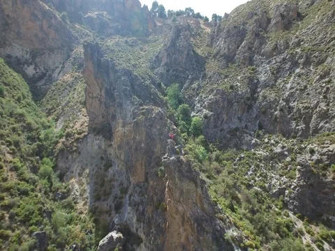 Reverse Aerial of jutting rock cliffs in the middle of a mountain valley Stock Footage 73473244
