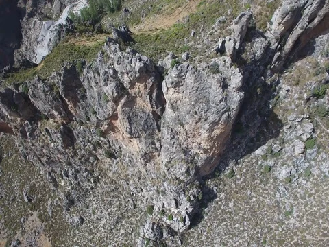 Reverse Aerial of large rock cliffs at the top of a mountain in the desert Stock Footage 73472705