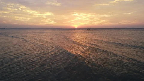 Reverse aerial of red sunset and rolling waves Stock-Footage 89884649