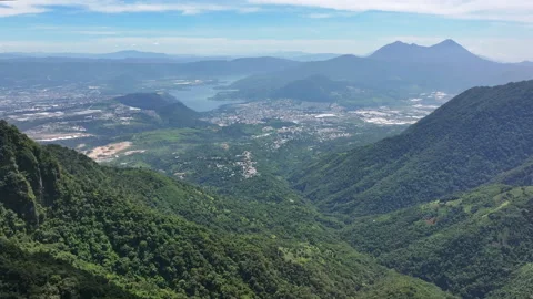 Reverse aerial tracking shot of mountains, lake and city in western Guatemala Video stock 319965486