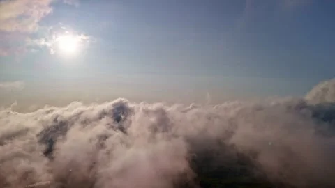 Reverse aerial view above cloud layer with sunlit sky captured from drone 스톡 동영상 332609904