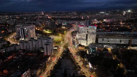 Reverse aerial view of Brasov Romania at night with city lights and car light Stock Footage 320657086