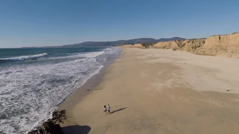 (Reverse Aerial View) Walking Along the Beach Stock Footage 87106862