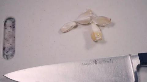 Reverse Angle of Young Man Placing Handful Of Fresh Garlic On Cutting Board 스톡 동영상 118330803
