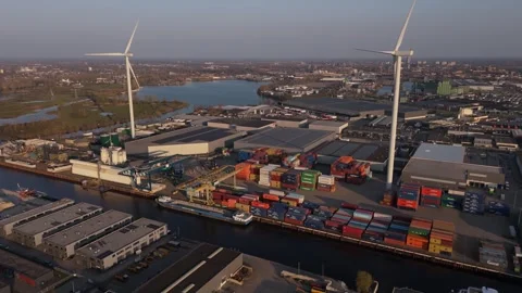 Reverse close aerial view of wind turbines and port context Stock Footage 335658657
