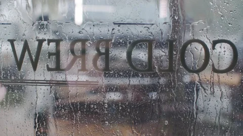 Reverse Cold Brew Graphic on Rainy Window Stock Footage 102236502