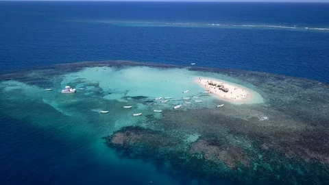 Reverse dolly view of a number of small boats anchored at tiny small sand Video stock 102746887