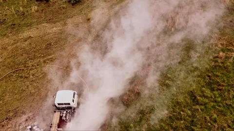 Reverse Drone Captures Drilling Machine Rig in a Smoky Grassy Field for Stock Footage 296785479