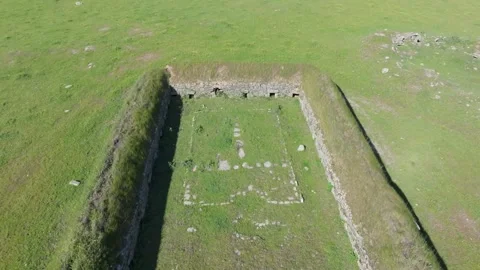 Reverse drone flight with camera turn revealing 18th-century pig farming site Stock Footage 308900333