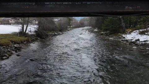 Reverse drone pass under bridge along alpine creek Stock Footage 342813019