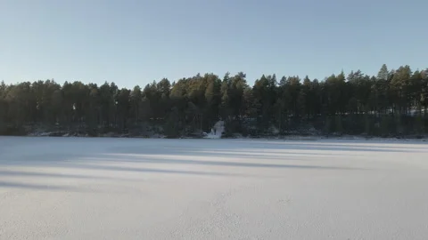 Reverse Drone Shot Of Two People Standing In Front Of A Frozen Lake Stock Footage 224251840