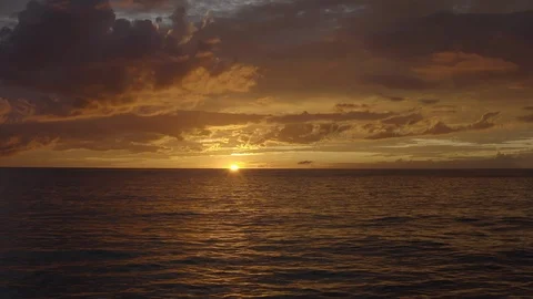 Reverse flying over the ocean surface at sunset in Caribbean Stock Footage 120872693