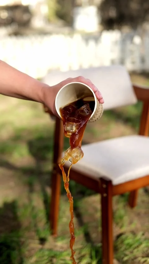 Reverse footage of iced coffee pouring out of a paper cup on the street. Stock Footage 307274351