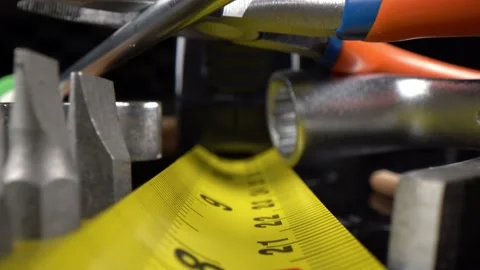Reverse macro footage of flat tape measure surrounded by tools Stock-Footage 150219661