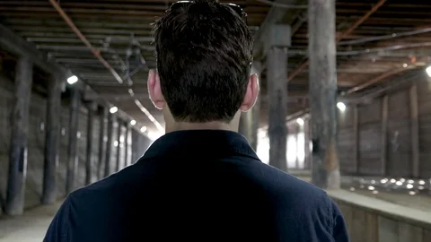 Reverse of man walking under a bridge, through a tunnel. Stock Footage 106140275
