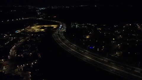 Reverse night time highway aerial flyover and light traffic Stock Footage 218534542