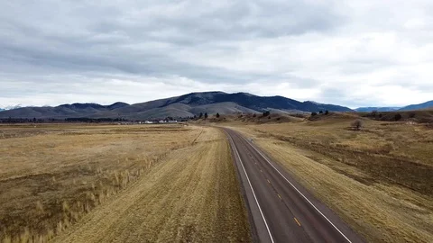 Reverse overhead shot above a rural highway with truck passing through toward Stock Footage 125054117
