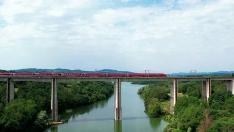Reverse Pan Slow-Aerial Train Freccia Rossa ETR 1000 Rail bridge passes by Stock-Footage 196784731