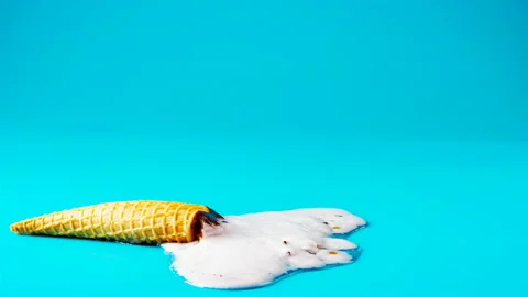 Reverse of peanut ice cream cone melting timelapse on blue background Stock Footage 108090066