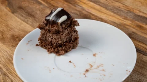 The Reverse Process of Eating a Chocolate Cake on a White Platter is a Stop Moti Stock Footage 125312180