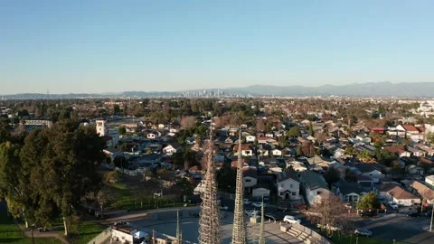 Reverse pullback aerial shot of the Watts Towers with downtown Los Angeles Stock-Footage 232486398