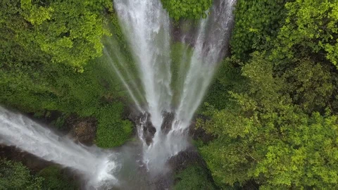 Reverse reveal tilting shot of massive Sekumpul waterfall cascading into jungle. 스톡 동영상 89953991