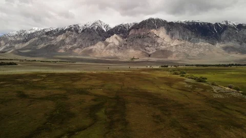 Reverse shot aerial of snow-capped Sierra mountains in background in Calif Stock Footage 109036558