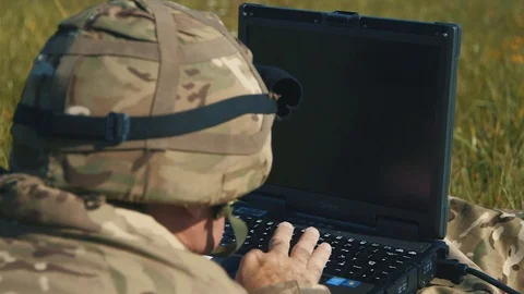 Reverse shot of soldier lying down and typing at computer Vidéo 93167111