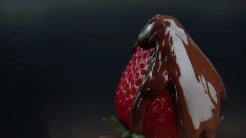 Reverse strawberry rotates and liquid chocolate flows and drops on it from above Stock Footage 202346010