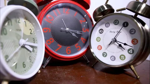 Reverse Time-Lapse of Three Antique Alarm Clocks on a Wooden Table Stock Footage 336643593