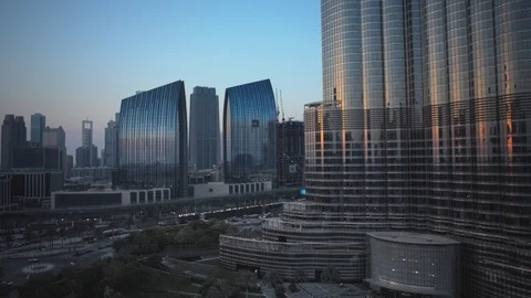Reverse track back slow pan left at base of Burj Khalifa at 60m, sunset. Stock Footage 98952181