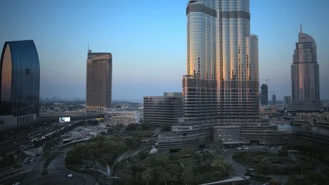 Reverse track back slow pan right at base of Burj Khalifa at 60m, sunset. Stock Footage 98952307